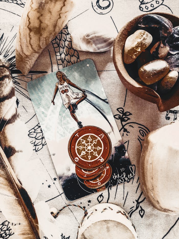 Close-up of a mystical tarot card with stones and feathers, evoking a magical atmosphere.