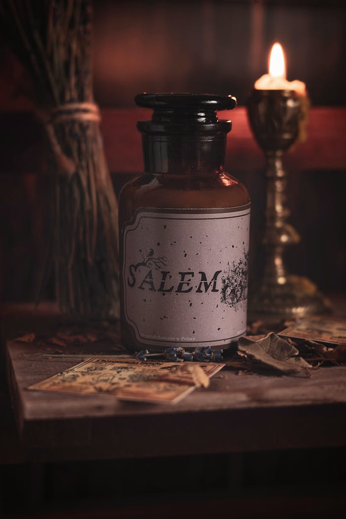 A vintage bottle labeled 'Salem' surrounded by candles and herbs captures a mystical apothecary vibe.